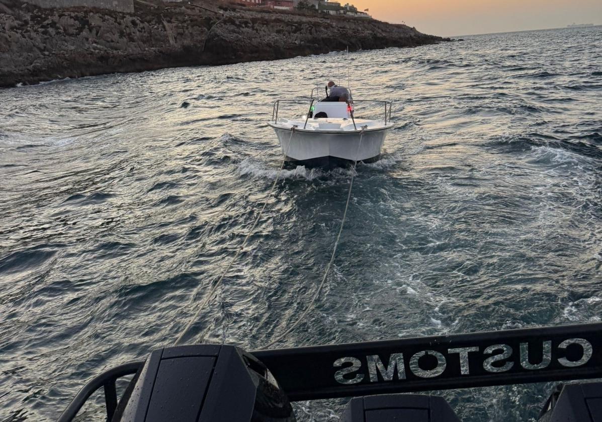 The small boat being towed back to the marina.