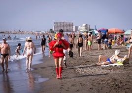 Who is the woman in red crossing the beaches of Malaga?
